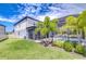 Backyard with a screened in pool, tropical landscaping, and green lawn at 12902 Brookside Moss Dr, Riverview, FL 33579