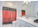 Bright bathroom featuring a vanity with quartz countertop and a decorative shower curtain at 12902 Brookside Moss Dr, Riverview, FL 33579