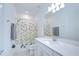 Bathroom with a shower-tub combo and single vanity with white cabinets and quartz countertop at 12902 Brookside Moss Dr, Riverview, FL 33579