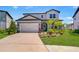 Charming two-story home with a well-manicured lawn, two car garage, and beautiful landscaping at 12902 Brookside Moss Dr, Riverview, FL 33579