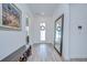 Light and bright foyer with wood flooring, shoe bench, mirror and natural light from front door at 12902 Brookside Moss Dr, Riverview, FL 33579