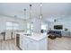 Open-concept kitchen featuring white cabinets, island with sink, and seamless flow to the dining and living areas at 12902 Brookside Moss Dr, Riverview, FL 33579