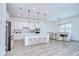 Modern kitchen with white cabinets, a large island, pendant lights, and stainless appliances at 12902 Brookside Moss Dr, Riverview, FL 33579