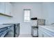 Well-lit laundry room with washer, dryer, cabinets, sink, and a view from the window at 12902 Brookside Moss Dr, Riverview, FL 33579