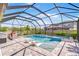 Backyard screened in pool and spa with outdoor kitchen and stone patio seating area at 12902 Brookside Moss Dr, Riverview, FL 33579