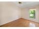 Comfortable bedroom offers wood floors and a large window with tree views at 13819 Stoneridge Dr, Hudson, FL 34669