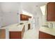 Kitchen featuring wooden cabinets, white tile floors, light countertops, and ample counter space at 13819 Stoneridge Dr, Hudson, FL 34669