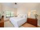 Tranquil main bedroom featuring light hardwood floors, complemented by a white bed set and neutral walls at 13819 Stoneridge Dr, Hudson, FL 34669