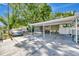 View of the front yard showing the covered car port and screened in porch at 1505 E 99Th Ave, Tampa, FL 33612