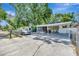 View of the front yard showing the covered car port and screened in porch of the home at 1505 E 99Th Ave, Tampa, FL 33612