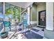 Cozy screened front porch with tiled flooring and views of the landscaped front yard at 1505 E 99Th Ave, Tampa, FL 33612