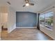 A bright bedroom with hardwood floors, a blue accent wall, a large window, and an ensuite bathroom at 15855 Fishhawk View Dr, Lithia, FL 33547