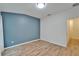 Bedroom boasts hardwood floors, a light blue accent wall, and an entrance to an attached bathroom at 15855 Fishhawk View Dr, Lithia, FL 33547