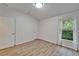 Bright bedroom features hardwood floors, white walls, and a window providing natural light at 15855 Fishhawk View Dr, Lithia, FL 33547