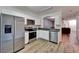 Open kitchen boasts stainless appliances, granite countertops, and a convenient pass-through to the living room at 15855 Fishhawk View Dr, Lithia, FL 33547