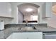Granite countertops surround a large stainless steel sink in this stylish and open kitchen space at 15855 Fishhawk View Dr, Lithia, FL 33547