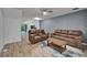 Cozy living room features leather sofas, a rug, and view into the kitchen at 15855 Fishhawk View Dr, Lithia, FL 33547