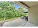 A covered patio offers outdoor seating and a backyard view of green foliage at 15855 Fishhawk View Dr, Lithia, FL 33547