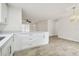 Bright, open kitchen featuring white cabinets, quartz countertops and modern wood-look tile floors at 1801 E Navajo Ave, Tampa, FL 33612