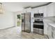 Updated kitchen with stainless steel appliances, modern cabinets, and wood-look tile flooring at 1801 E Navajo Ave, Tampa, FL 33612