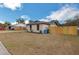 A view of the house and its backyard with a wood fence at 1818 Kim Acres Ln, Dover, FL 33527