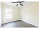 Bright bedroom with modern ceiling fan, wood-look floors, and a large window at 1818 Kim Acres Ln, Dover, FL 33527