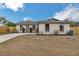 Single-story home featuring a well-manicured lawn, front garden beds and a freshly-painted exterior at 1818 Kim Acres Ln, Dover, FL 33527