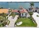 Aerial view of property showcasing lush landscaping, circular driveway, and Mediterranean-style architecture at 191 1St W St, Tierra Verde, FL 33715