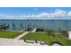 Backyard featuring lush green grass, dock, and bay views at 191 1St W St, Tierra Verde, FL 33715