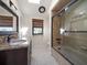 Modern bathroom featuring a granite vanity, decorative mirror, and glass-enclosed shower at 191 1St W St, Tierra Verde, FL 33715
