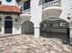 Exterior of the home with arched entryways and beautiful paver driveway at 191 1St W St, Tierra Verde, FL 33715
