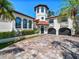 Striking front exterior of home with mature trees, manicured landscaping and circular driveway at 191 1St W St, Tierra Verde, FL 33715