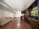 Open living room with custom cabinetry, wet bar, tile floors, microwave, mini fridge, and neutral-toned sofa at 191 1St W St, Tierra Verde, FL 33715