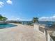 An outdoor kitchen with a grill on a stone patio overlooking the water at 191 1St W St, Tierra Verde, FL 33715