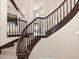 Elegant curved staircase with dark wood railings and tile steps at 191 1St W St, Tierra Verde, FL 33715