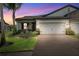 Beautiful one-story home exterior at twilight with a brick driveway at 19323 Hawk Valley Dr, Tampa, FL 33647