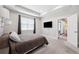 Well-lit main bedroom featuring neutral tones, tray ceiling, and access to other rooms via a door at 19323 Hawk Valley Dr, Tampa, FL 33647