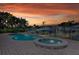Backyard pool and spa with brick patio surrounded by lush tropical landscaping with sunset view at 2017 Iowa Ne Ave, St Petersburg, FL 33703
