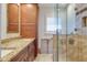 Bathroom featuring a granite countertop vanity, a tiled walk-in shower, and a large window at 2017 Iowa Ne Ave, St Petersburg, FL 33703