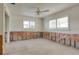 Bedroom ready to be renovated, featuring large windows, exposed wall studs, and a ceiling fan at 2017 Iowa Ne Ave, St Petersburg, FL 33703