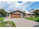 Charming home featuring a brick-accented facade, well-manicured lawn, and a spacious driveway at 2017 Iowa Ne Ave, St Petersburg, FL 33703