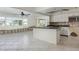 Open kitchen featuring an island, granite countertops, and white cabinetry ready for renovation at 2017 Iowa Ne Ave, St Petersburg, FL 33703