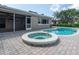 Backyard view of a refreshing pool and spa with brick patio, perfect for relaxing and entertaining guests at 2017 Iowa Ne Ave, St Petersburg, FL 33703