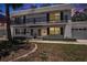 Charming condo at dusk with a balcony, manicured lawn, and a one-car garage in a tranquil neighborhood at 202 Mindy Dr, Largo, FL 33771
