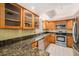 Classic kitchen featuring stainless steel appliances, granite countertops, and wooden cabinetry at 202 Mindy Dr, Largo, FL 33771