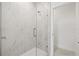 Bathroom featuring a glass-enclosed shower with elegant marble tile surround and bright, neutral tones at 2043 Wild Heron Ct, Valrico, FL 33596