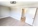 Bedroom with wood-look floors, neutral walls, and an open doorway to the hallway and en-suite bathroom at 2205 Belleair Rd # A36, Clearwater, FL 33764