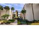 Inviting condo exterior with lush landscaping, mature palm trees, and accessible parking in a serene setting at 2205 Belleair Rd # A36, Clearwater, FL 33764