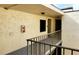 Exterior hallway featuring stucco walls, bronze railing, and an extinguisher on the wall at 2205 Belleair Rd # A36, Clearwater, FL 33764