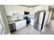 Modern kitchen with white cabinets, stainless steel appliances, and luxury vinyl plank flooring at 2205 Belleair Rd # A36, Clearwater, FL 33764